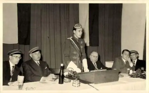 Studentika Foto Ak Student hält eine Rede, Menschen am Tisch