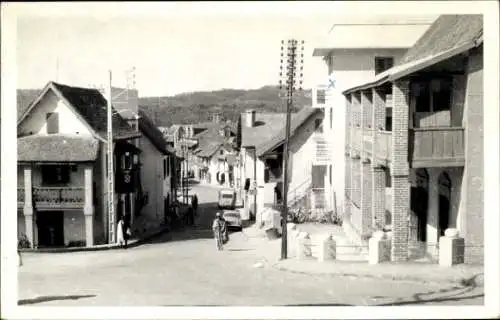 Ak Madagaskar Madagascar, Schwarzes und weißes Bild, Straße, Häuser, Auto, Berge im Hintergrund