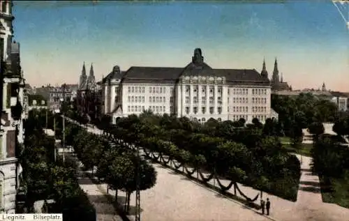Ak Legnica Liegnitz Schlesien,  Bilseplatz, s Gebäude, weitläufige Allee, umgeben von Bäumen
