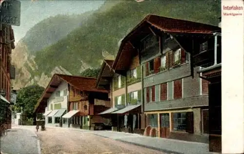 Ak Interlaken Kanton Bern Schweiz, Marktgasse, Häuser mit Balkonen, Berge im Hintergrund, ruhige 