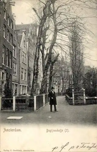 Ak Amsterdam Nordholland Niederlande,  Begijnenhof, Ein Mann in Schwarz, Bäume, Häuser