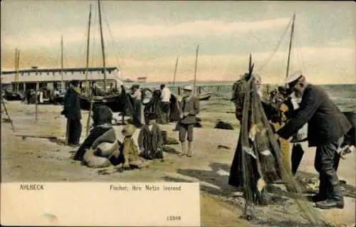 Ak Ostseebad Ahlbeck auf Usedom, Fischer am Strand, Netze leerend, Boote, Häuser im Hintergrund