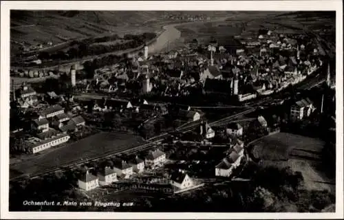 Ak Ochsenfurt am Main Unterfranken, Luftaufnahme von Ochsenfurt,  Gebäude, Fluss, Eisenbahnlinie