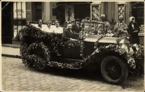 Foto Ak Männer und Frauen in einem Automobil, Blumenschmuck