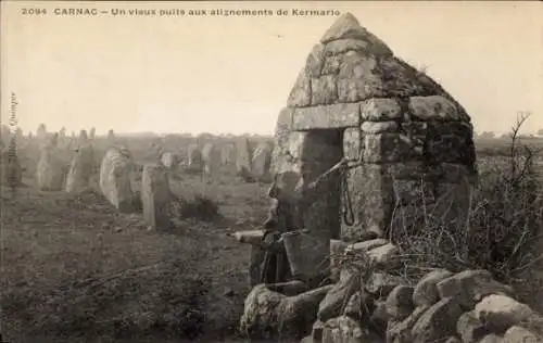 Ak Carnac Morbihan, Vorseite mit alten Steinstellungen, ein Brunnen, eine Person mit Eimer