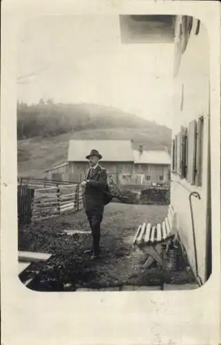 Foto Ak Jäger mit Gewehr, Wohnhaus