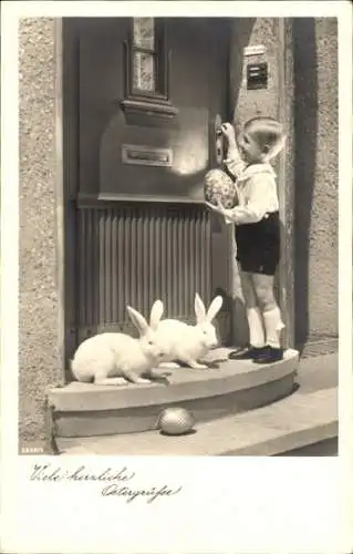 Ak Fröhliche Ostern, zwei weiße Hasen und kleiner Junge mit Osterei