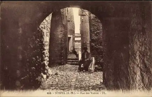 Ak Sospel Alpes Maritimes, Alte Gasse, Kopfsteinpflaster, Blick auf Gebäude, sitzende Person