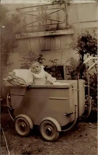 Foto Ak Baby sitzt in einem Kinderwagen