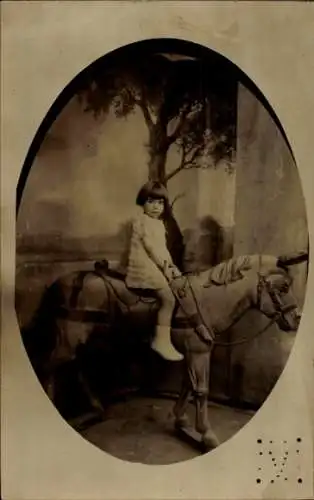 Foto Ak Mädchen posiert auf Holzpferd