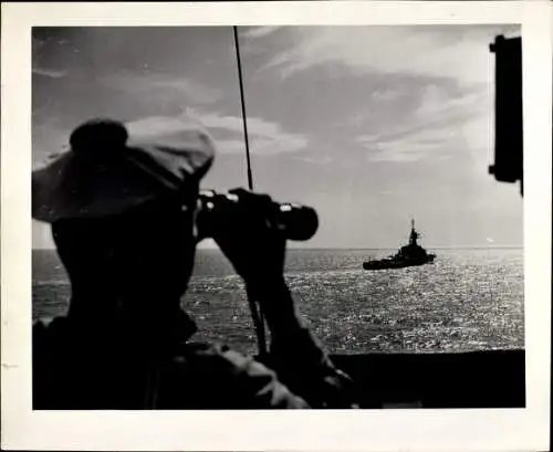 Foto Marinesoldat beobachtet durch Fernglas ein Kriegsschiff