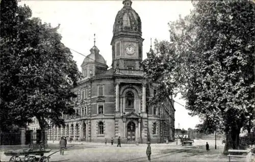 Ak Legnica Liegnitz Schlesien, Historisches Gebäude mit Uhrturm, Kopfsteinpflasterstraße, Bäume, 