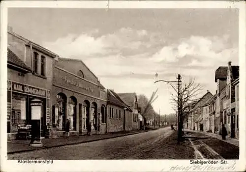 Ak Klostermansfeld in Sachsen Anhalt, Blick auf die Siebigeröder Str., Geschäfte, Bäume, Wolken