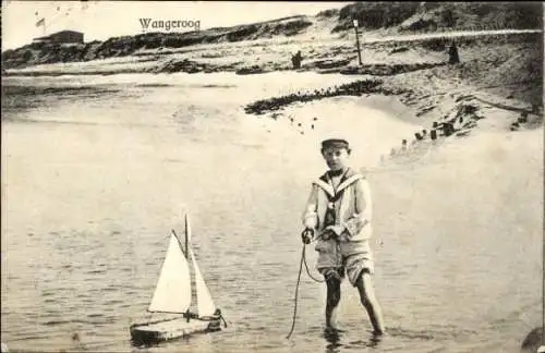 Ak Wangerooge in Friesland, Junge in Matrosenuniform im Wasser mit kleinem Bötchen 