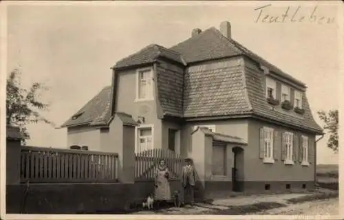 Ak Teutleben Hörsel Thüringen, Haus mit Sandsteinsockel, zwei Personen, Holzpferd, Schrift 'Teutl