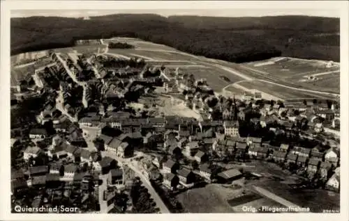 Ak Quierschied im Saarland, Luftaufnahme, Ort mit Häusern und Kirche, Wald im Hintergrund, Fliege