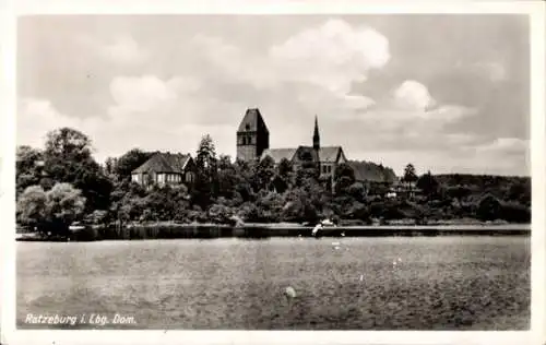 Ak Ratzeburg im Herzogtum Lauenburg, Dom und Gebäude am Wasser, bewaldete Umgebung, Wolkenhimmel