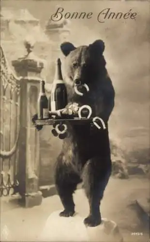 Ak Fröhliches Neujahr, Bär trägt Tablett mit Sektflaschen, Hufeisen und Kleeblättern