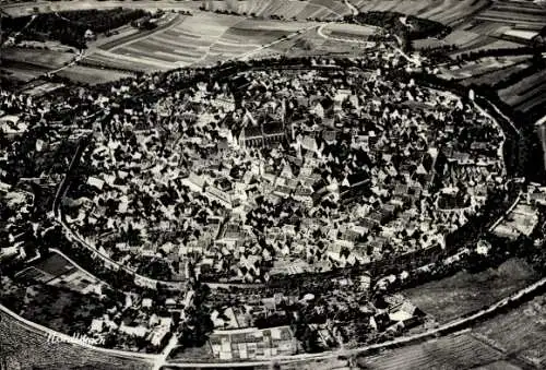 Ak Nördlingen in Schwaben, Luftaufnahme, kreisförmige Stadt, viele Dächer, grüne Felder