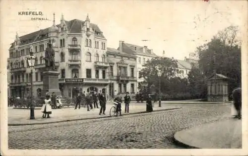 Ak Krefeld am Niederrhein, Gebäude, Statue, Menschen in n Kleidern, Stadtplatz