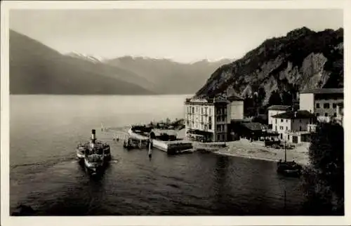 Ak Varenna Lombardia, Schiff im Hafen, Berglandschaft, Gebäude am Ufer, ruhiges Wasser