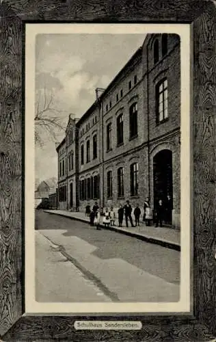 Ak Sandersleben in Anhalt, Schulhaus   Architektur, Straße mit Leuten