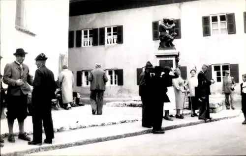 Ak Mittenwald in Oberbayern, Veranstaltung, Personen in r Kleidung, Gebäude im Hintergrund, Statu