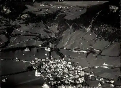 Ak Reutte in Tirol, Blick auf  eine kleine Stadt in den Bergen mit vielen Häusern und einer Ki...