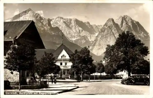 Ak Garmisch Partenkirchen in Oberbayern, Marktplatz, Zugspitzgruppe, Berge, alte Autos, Bäume