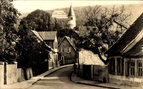 Ak Gernrode Quedlinburg im Harz, Straße mit Häusern, Kirche im Hintergrund, Schwarz-Weiß-Foto