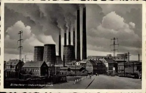 Ak Bitterfeld in Sachsen Anhalt, Industriegebäude, rauchende Schornsteine, Wolken, Straßenansicht