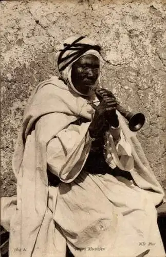 Ak afrikanischer Musiker spielt Blasinstrument
