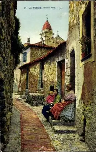 Ak La Turbie Alpes Maritimes, Alte Straße, drei Frauen sitzend, Kirche im Hintergrund