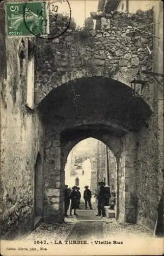 Ak La Turbie Alpes Maritimes, Alter Straßenblick, Menschen gruppiert, Brücke, Gebäude, Laterne