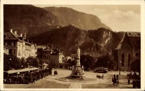 Ak Bozen Bolzano Südtirol, Platz mit Brunnen, Gebäude, Berge im Hintergrund, Straßenbahn