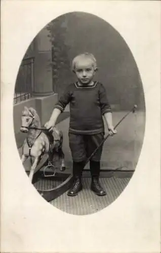 Foto Ak Junge mit Schaukelpferd, Porträt