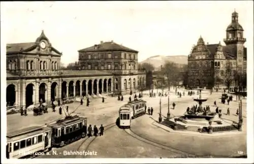 Ak Heilbronn am Neckar, Bahnhofplatz, alte Gebäude, Straßenbahnen, Brunnen, Menschen