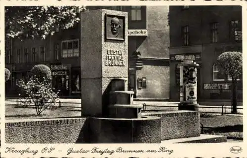 Ak Kluczbork Kreuzburg Oberschlesien, Gustav Freytag Brunnen, Buchhandlung, Apotheke, Tengelmann,