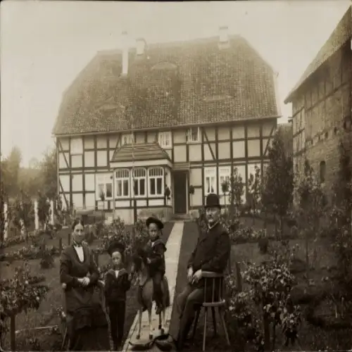 Foto Ak Marienburg Malbork Westpreußen, Fachwerkhaus, Familie im Garten, Junge auf Spielzeugpferd