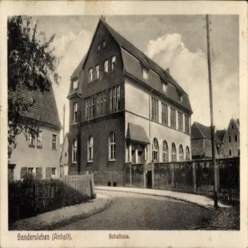 Ak Sandersleben in Anhalt,  Schulhaus,  Architektur, Straße, Bäume