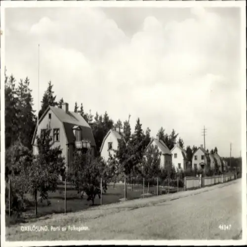 Ak Oxelösund Södermanlands Schweden, Häuserreihe, Straße, Bäume, Wolken, Siedlungsgebiet