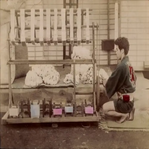 Foto Japan, Junger Mann bei der Arbeit an einem Spinnrad, coloriert