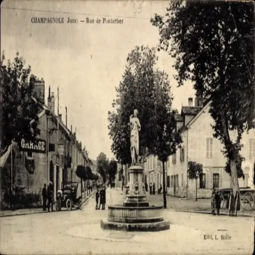 Ak Champagnole Jura, Statue auf Brunnen, Straßenansicht, Gebäude, Garage