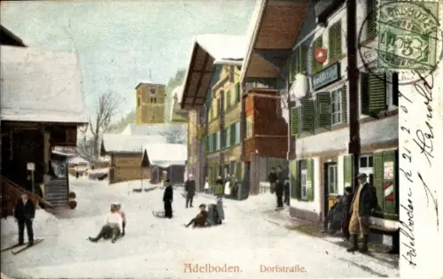Ak Adelboden Kanton Bern Schweiz, Dorfstraße in  Schnee,  Gebäude, Menschen