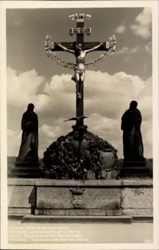 Ak Praha Prag Tschechien, Kreuz auf der Karlsbrücke, Statue, Inschrift in mehreren Sprachen