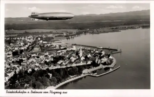 Ak Friedrichshafen am Bodensee, Luftaufnahme von Friedrichshafen, Bodensee, Zeppelin im Himmel