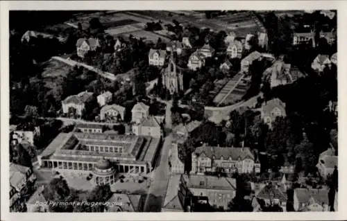 Ak Bad Pyrmont in Niedersachsen, Luftaufnahme von  Gebäude, Bäume, Kirchen
