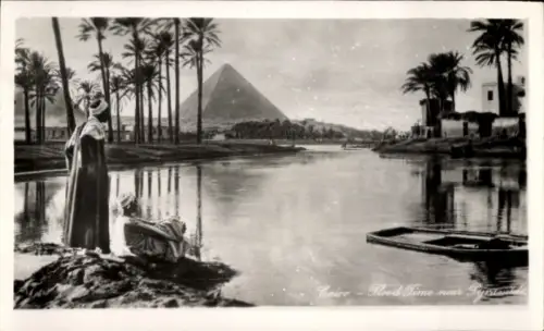 Ak Gizeh Ägypten, Flusslandschaft, Pyramide im Hintergrund, Palmen, Menschen am Ufer