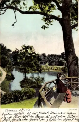 Ak Chemnitz in Sachsen, Stadtpark in  ruhige Landschaft, Teich, Frau sitzt auf einer Bank