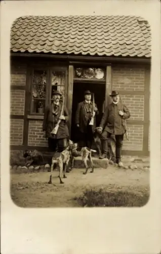 Foto Ak Jäger mit Gewehren und Hunden am Backsteinhaus